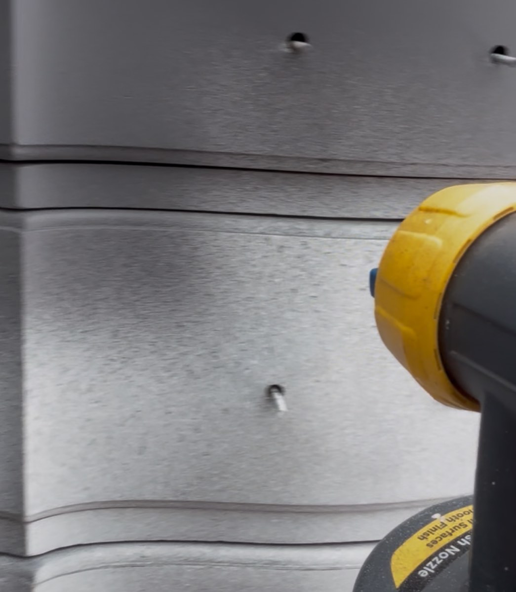 Close-up of the spray nozzle dialing in the finish