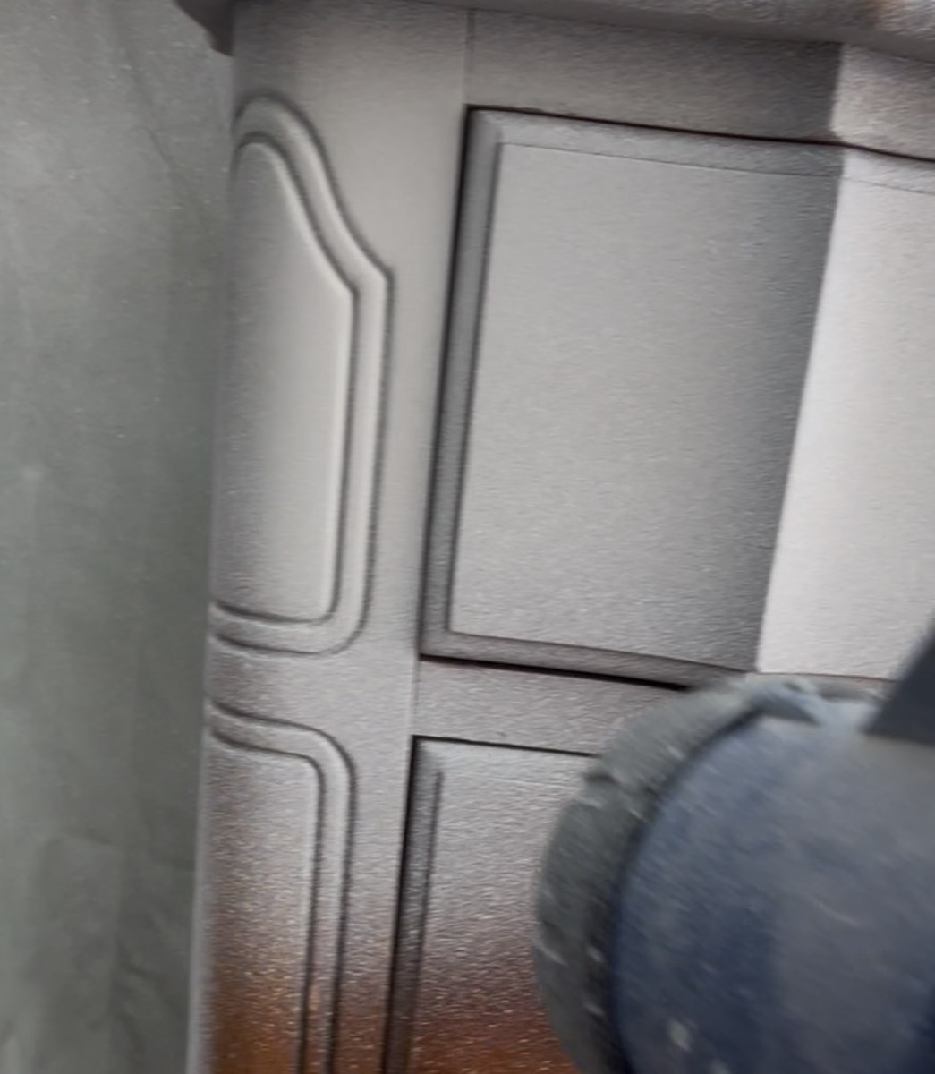 Spray gun applying a smooth finish to a drawer front